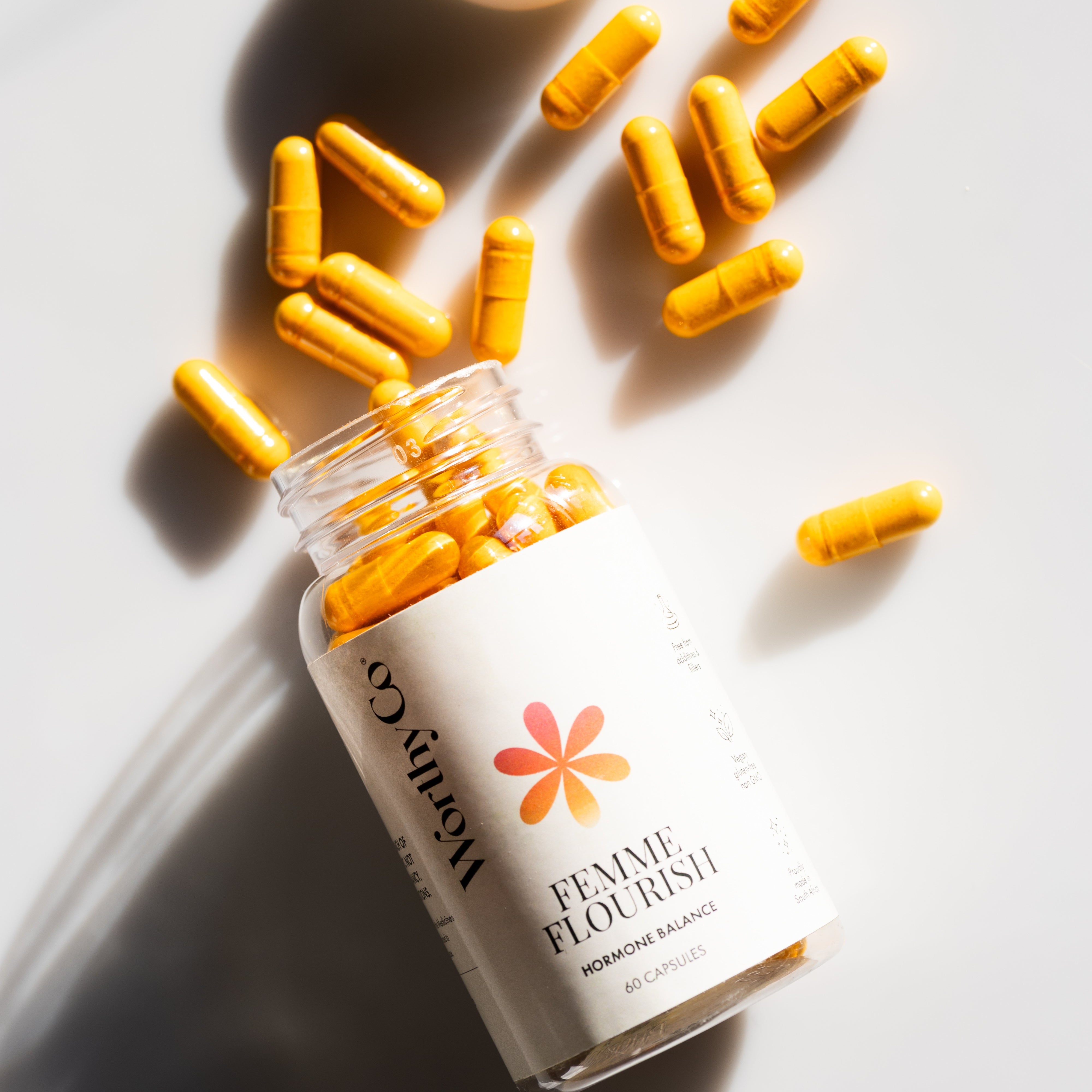 Bottle of 'Female Flourish' supplements with capsules on a light background